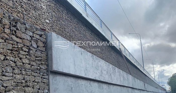 Retaining wall on the M12 motorway built with gabions and TEXPOLIMER geosynthetics: RD geogrid, geomembrane and geotextile.